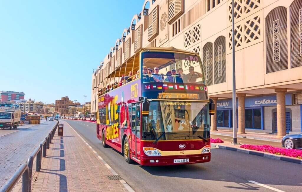 Open top tour bus carrying tourists for Dubai city sightseeing and tours transport services